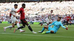 Kiper Tottenham Hotspur, Guglielmo Vicario (kanan) menghalau bola tendangan pemain Manchester United, Marcus Rashford (tengah) pada laga pekan kedua Liga Inggris 2023/2024 di Tottenham Hotspur Stadium, London, Inggris, Minggu (20/08/2023) WIB. (AFP/Adrian Dennis)