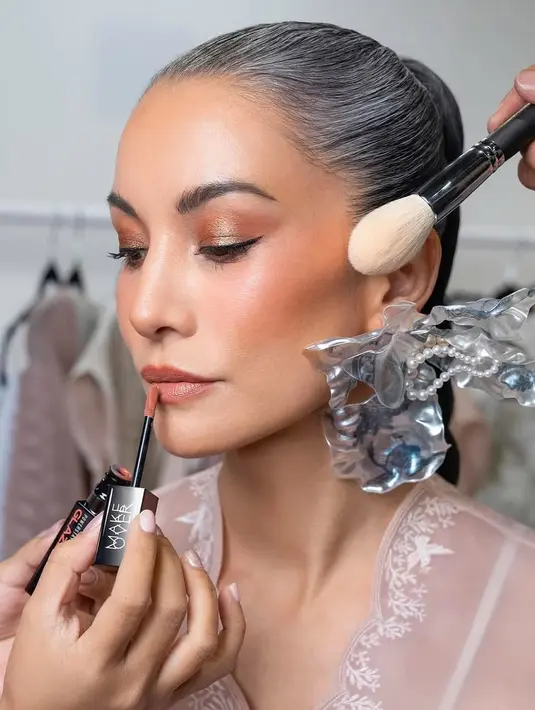 Ia tampil percaya diri dengan rambut beruban yang ditata sleek braided ponytail. Wajahnya dipulas dengan latte makeup look [@nadyahutagalung]