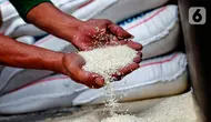 Pekerja menunjukkan beras yang akan dijual di toko beras di Pasar Kebayoran Lama, Jakarta, Jumat (5/5/2023). Kenaikan harga beras menjadi salah satu penyumbang inflasi Indeks Harga Konsumen pada April 2023. (Liputan6.com/Angga Yuniar)