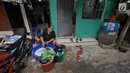 Warga mencuci pakaian di depan rumahnya di Kawasan Muara Baru, Jakarta, Selasa (9/7/2019). Pada saat musim kemarau air sumur tidak mengalir deras, untuk memenuhi air bersih warga dalam sehari mengeluarkan uang Rp. 15.000 untuk membeli enam derigen untuk air bersih. (Liputan6.com/Herman Zakharia)
