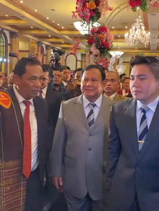 Bakal calon presiden Prabowo Subianto juga datang dan sempat diminta buat memasangkan ulos kepada mempelai pengantin. Ia mengenakan setelan jas warna abu-abu. [@fcgweddings]