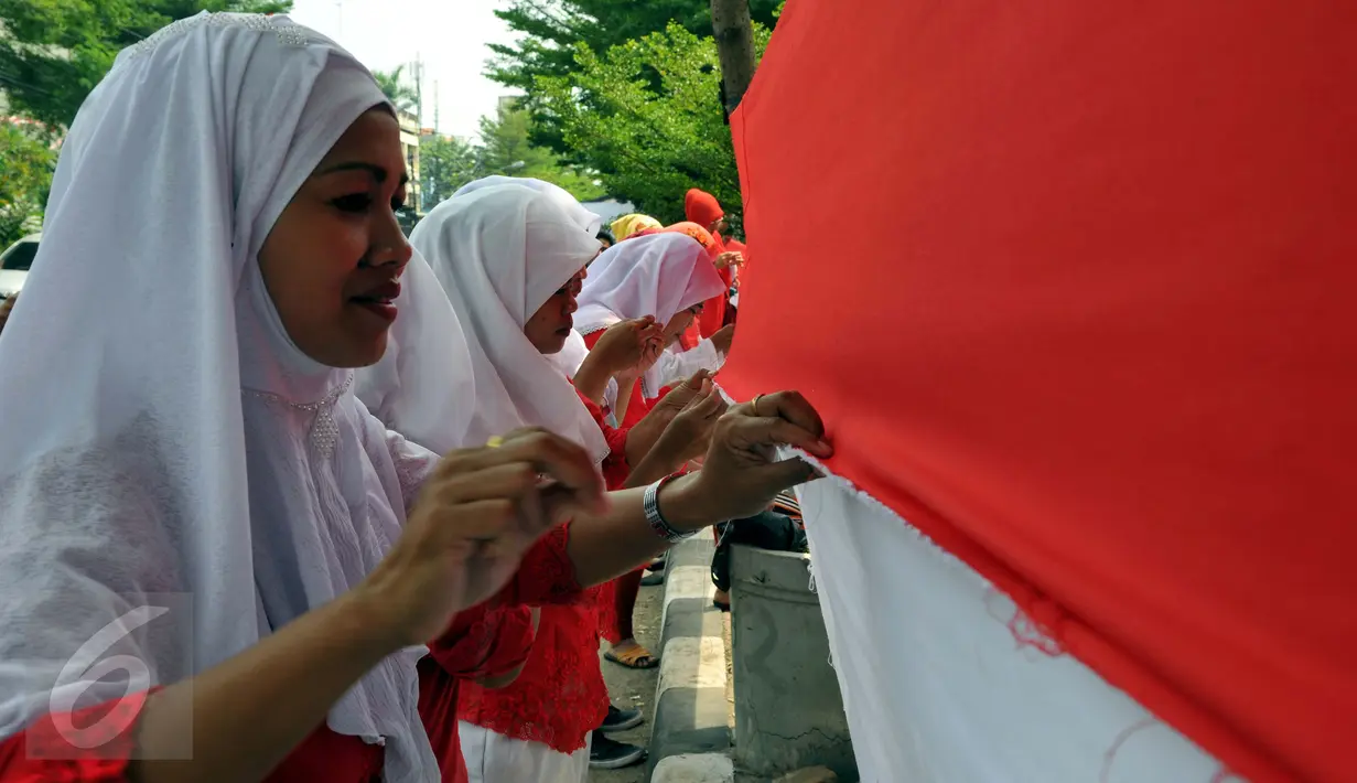 Sejumlah warga saat mengikuti lomba menjahit bendera Merah Putih sepanjang 500 meter di Kelurahan Pekojan, Jakarta, Minggu (16/8/2015). Lomba yg di ikuti oleh 12 RW dan 144 RT ini mengirimkan lima orang dlm setiap Rtnya. (Liputan6.com/Panji Diksana)