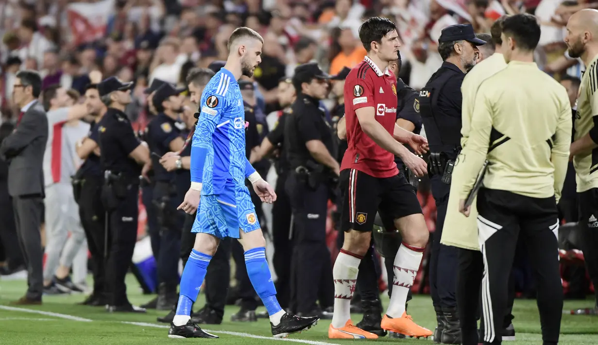 Pemain Manchester United, David De Gea dan Harry Maguire meninggalkan lapangan setelah ditaklukkan Sevilla pada leg kedua perempat final di Ramon Sanchez Pizjuan, Jumat (21/4/2023). Kedua pemain ini menjadi sorotan lantaran menjadi biang kerok kekalahan Setan Merah. (AFP/Cristina Quicler)