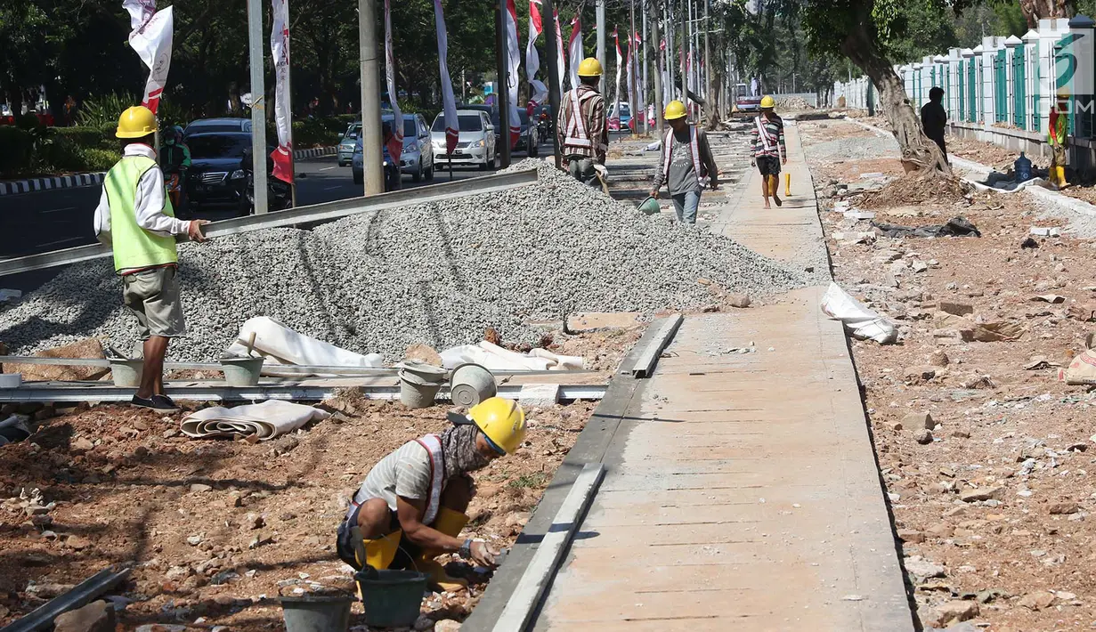 Suasana penyelesaian pembuatan trotoar di kawasan Senayan, Jakarta, Senin (28/8). Pembuatan trotoar dilakukan dalam rangka menyambut event Asian Games 2018 mendatang yang akan digelar di Jakarta dan Palembang. (Liputan6.com/Immanuel Antonius)