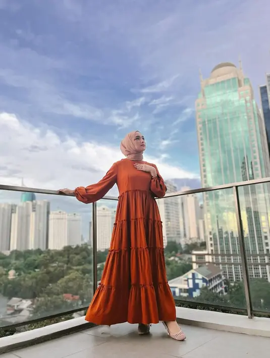 <p>Satu lagi inspirasi tampil kasual, namun tetap terlihat elegan. Di sini Citra Kirana terlihat mengenakan long dress berwarna oranye dengan detail kerut bertumpuk. Ia sempurnakan penampilannya ini dengan jilbab merah muda dan high heels. Foto: Instagram.</p>