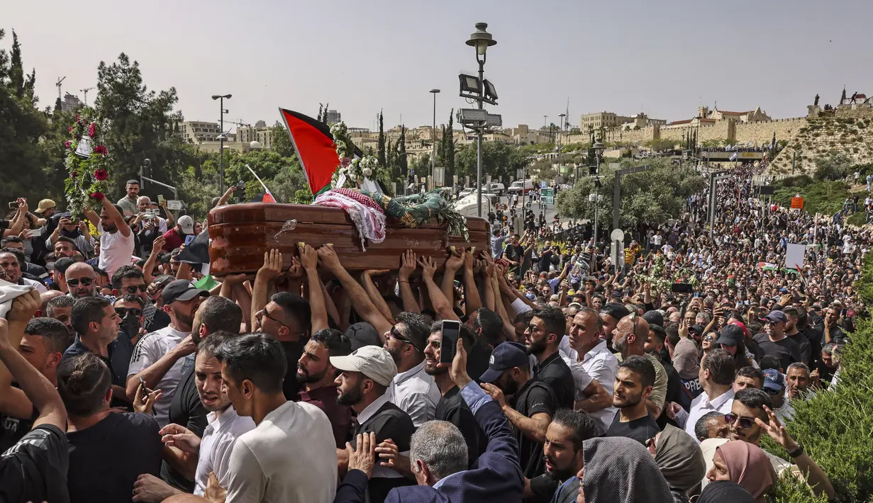 <p>Pelayat Palestina membawa peti mati jurnalis Al-Jazeera Shireen Abu Akleh yang tewas tertembak, selama prosesi pemakamannya dari gereja menuju pemakaman, di Yerusalem, pada 13 Mei 2022. Shireen Abu Akleh yang merupakan jurnalis senior berusia 51 tahun itu terkena tembakan di kepala ketika meliput serangan Israel di Kota Jenin, di wilayah Tepi Barat yang diduduki pada 11 Mei 2022 lalu. (RONALDO SCHEMIDT / AFP)</p>