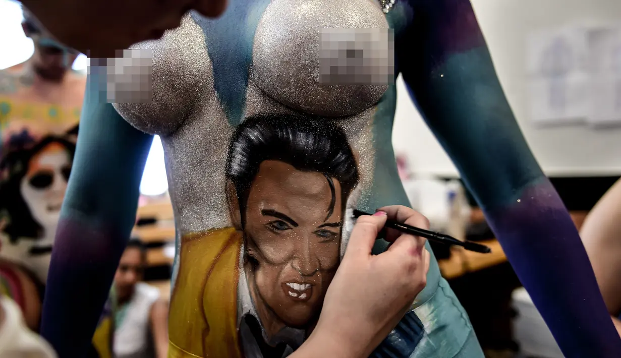Seorang model menunjukkan tubuhnya dilukis oleh mahasiswa seni lembaga Chili AIEP selama pameran body painting, Santiago (24/11/2015). Lebih dari 100 desain yang terinspirasi oleh ikon musik, dipamerkan dalam pameran tersebut (AFP Photo/Martin Bernetti)