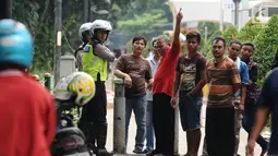 Petugas kepolisian melakukan sosialisasi dengan warga di trotoar Jalan Kebon Sirih, Jakarta, Senin (17/7). Hal ini tindak lanjut maraknya pelanggaran lalu lintas di kawasan pedestrian Jalan Kebon Sirih. (Liputan6.com/Helmi Fithriansyah)