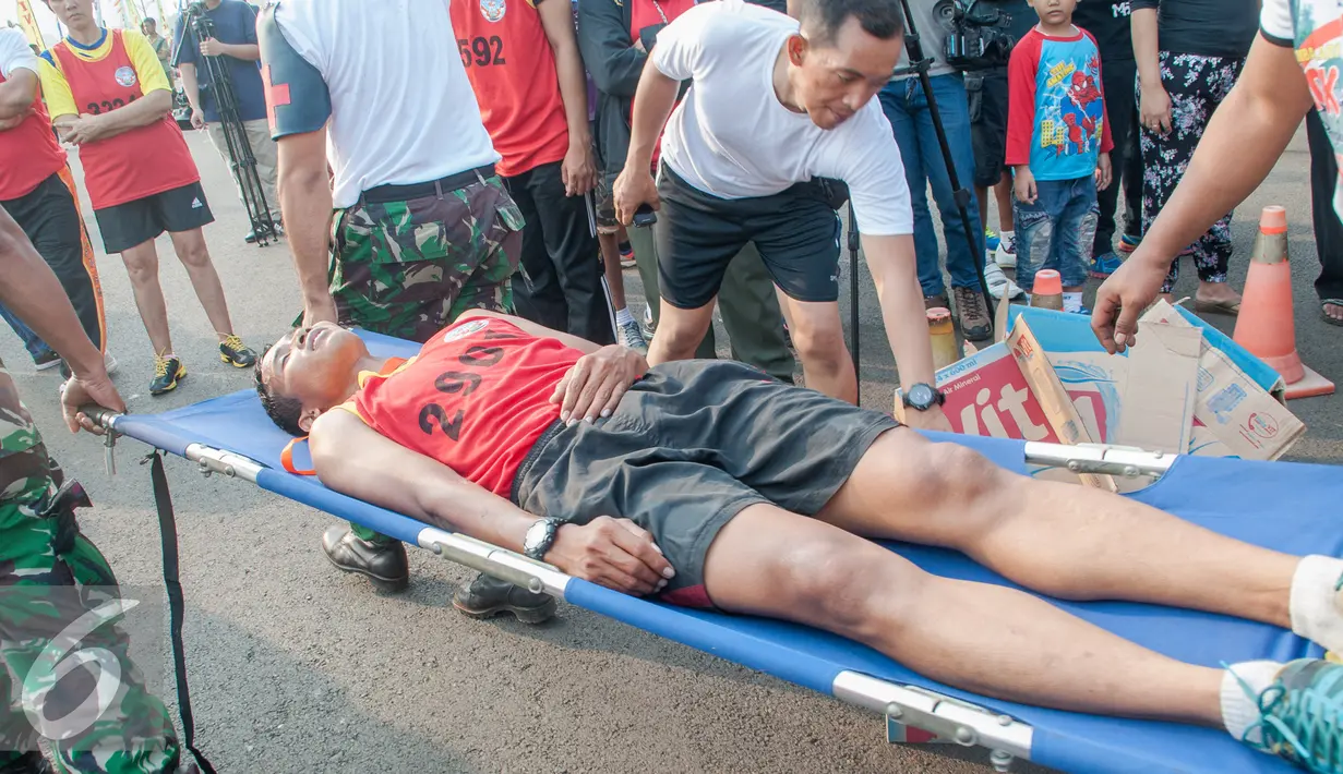 Peserta ditanduh oleh petugas saat mengikuti lomba lari 10K di Silang Monas, Jakarta, Minggu (27/9/2015). Lomba lari tersebut dibuka oleh Panglima TNI Jenderal TNI Gatot Nurmantyo dan digelar untuk memperingati Hut TNI ke 70. (Liputan6.com/Faizal Fanani)