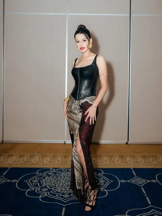 Suzana Sameh mengenakan atasan sleeveless leather korset dipadukan bawahan kain batik dengan potongan tinggi. [@susansameeh]