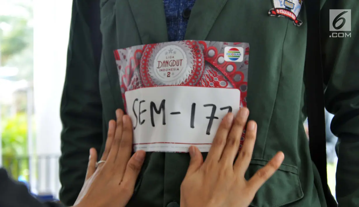 Panitia memasang nomor ke tubuh peserta audisi Liga Dangdut Indonesia 2 (LIDA 2) di Wisma Perdamaian Semarang, Jawa Tengah, Minggu (16/12). Indosiar menggelar audisi LIDA 2 secara serentak di tiga provinsi hari ini. (Liputan6.com/Gholib)