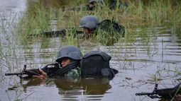 Prajurit TNI dari Batalyon Infanteri Raider bersiap menembak dari air saat latihan perang gerilya di pangkalan mereka di Banda Aceh, provinsi Aceh, 30 April 2019.  Prajurit batalion raider dilatih  untuk siap melakukan berbagai operasi khusus dan penugasan mendadak. (CHAIDEER MAHYUDDIN / AFP)