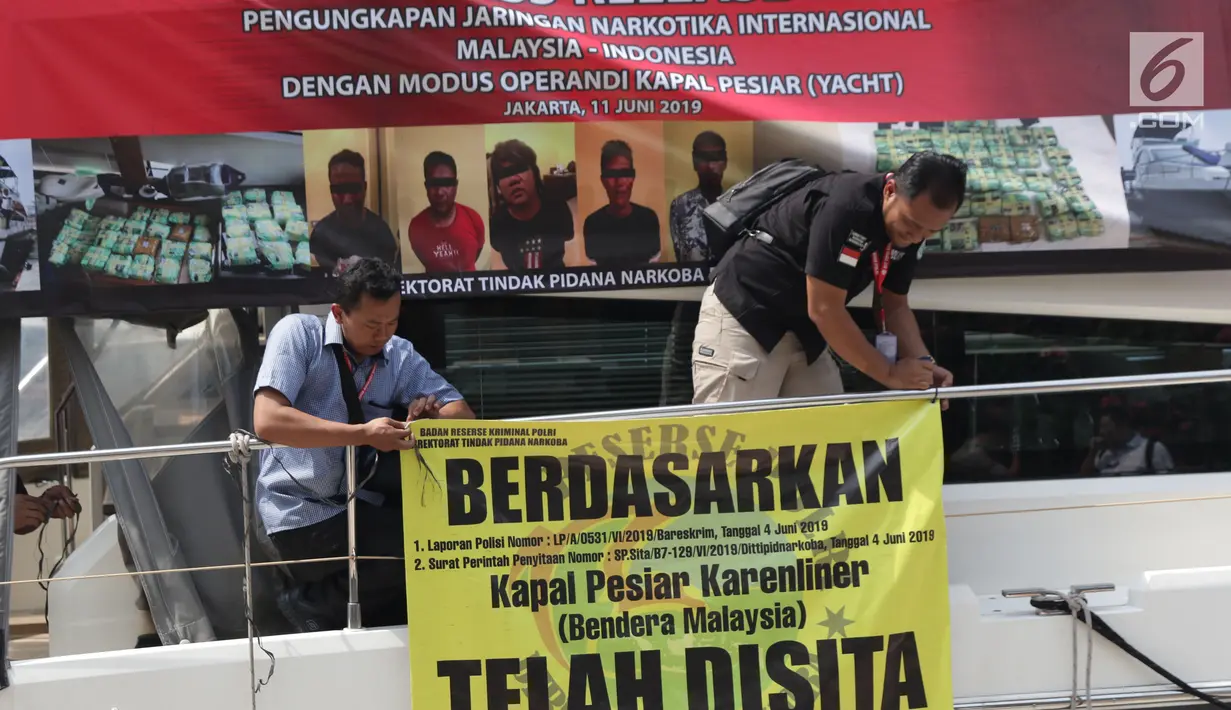 Petugas Dirtidpid Bareskrim Polri memasang spanduk penyitaan kapal pesiar Karenliner di Pelabuhan Batavia Marina, Jakarta, Selasa (11/6/2019). Dirtidpid Narkoba Bareskrim Polri mengungkap penyelundupan 37 kg sabu asal Malaysia sabu dengan menggunakan kapal pesiar. (Liputan6.com/Helmi Fithriansyah)