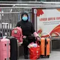 Para pelancong duduk dengan barang-barang mereka di luar Stasiun Kereta Api Hankou yang ditutup di Wuhan, Provinsi Hubei, China, Kamis (23/1/2020). Pemerintah China mengisolasi Kota Wuhan yang berpenduduk sekitar 11 juta jiwa untuk menahan penyebaran virus corona. (Chinatopix via AP)
