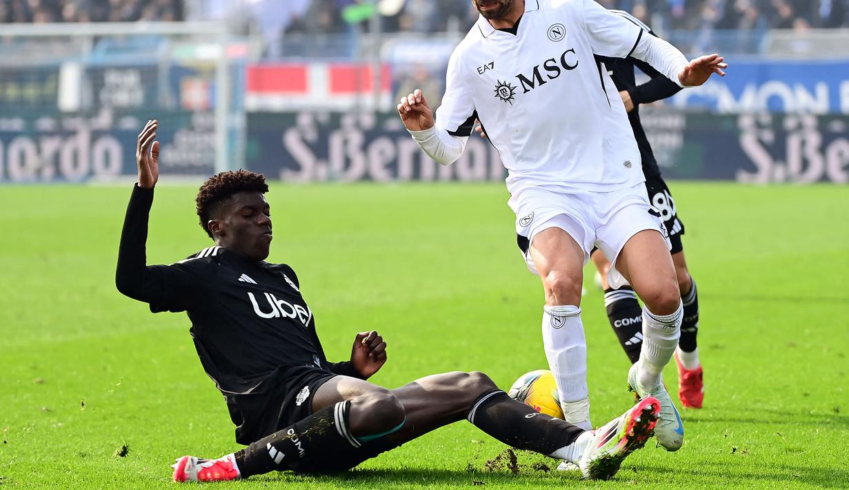 Pemain Como, Assane Diao berusaha merebut bola dari pemain Napoli dalam laga lanjutan Liga Italia 2024/2025 di Giuseppe-Sinigaglia Stadium, Como, Italia, Minggu (23/02/2025) waktu setempat. (AFP/Piero Cruciatti)