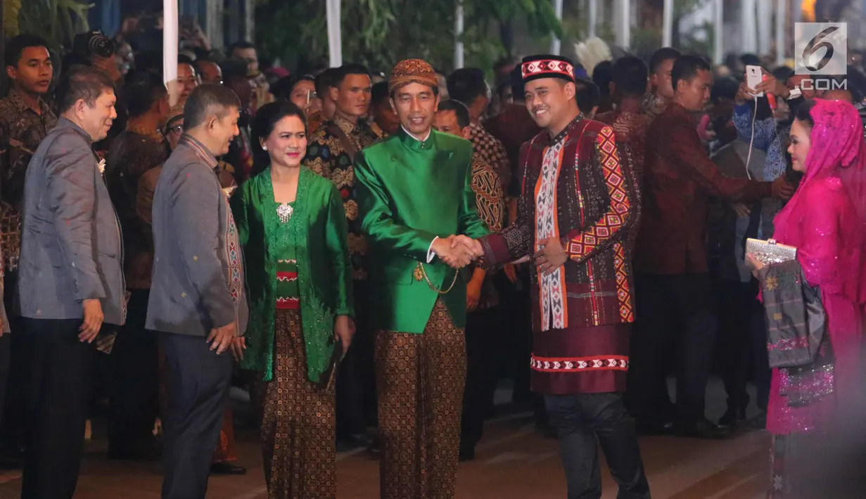 Presiden Jokowi berjabat tangan dengan mempelai pria Bobby Nasution pada acara serah terima Paningset dan Midodareni di kediamannya di Surakarta, Selasa (7/11). (Liputan6.com/Angga Yuniar)