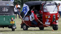 Peserta saling berebut bola saat pertandingan "Tuk Tuk Polo" di Galle, Sri Lanka, (21/2). Olahraga Polo yang biasa mengunakan kuda, hadir di Sri Lanka dengan penampilan unik menggunakan bajaj atau Tuk-tuk. (REUTERS/Dinuka Liyanawatte)