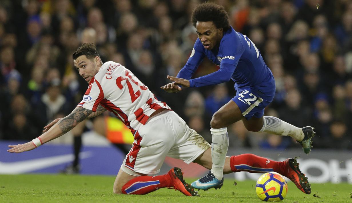 Pemain Chelsea, Willian (kanan) jatuh saat berebut bola dengan pemain Stoke City, Geoff Cameron pada lanjutan Premier League di Stamford Bridge, London (30/12/2017). Chelsea menang 5-0. (AP/Alastair Grant)