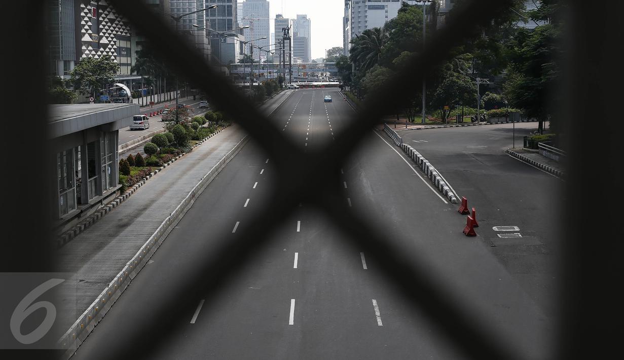 Sebuah taksi melintasi jalan protokol yang lengang di kawasan MH Thamrin, Jakarta, Selasa (6/7). Hampir semua jalan di Ibu Kota lengang saat sebagian besar warga mudik untuk merayakan Lebaran di kampung halaman. (Liputan6.com/Faizal Fanani)