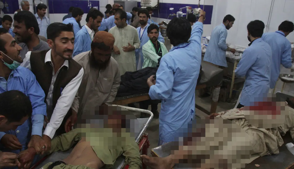 Petugas medis mengevakuasi sejumlah korban ledakan bom bunuh diri di Quetta, Pakistan, (13/7). ISIS telah menyatakan bertanggung jawab atas aksi serangan bom bunuh diri tersebut. (AP Photo/Arshad Butt)