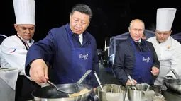 Aksi Presiden Rusia Vladimir Putin (dua kanan) dan Presiden China Xi Jinping (kedua kiri) saat membuat pancake bersama di sela acara Eastern Economic Forum di Vladivostok, Rusia, Selasa (11/9). (Sergei Bobylev/TASS News Agency Pool Photo via AP)