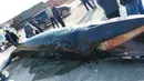 Sejumlah warga berkumpul di dekat bangkai ikan paus dengan panjang sekitar 8,9 meter dan berat 3,9 ton yang ditemukan mati terdampar di pinggiran pantai dekat kota Rizhao, provinsi Shandong, China, 30 November 2015. (shanghaiist.com)