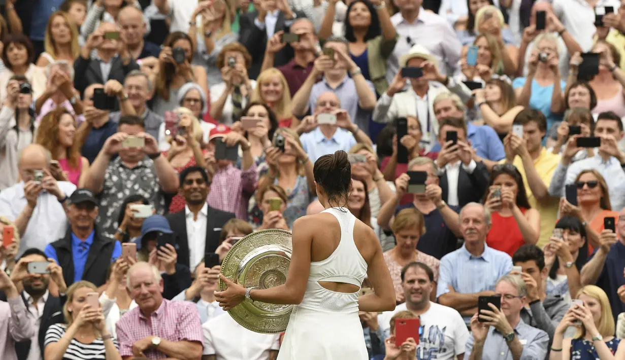 Penonton mengabadikan kemenangan petenis Spanyol, Garbine Muguruza, meraih juara Wimbledon usai menaklukkan Venus Williams di All England Lawn Tennis Club, Inggris, Sabtu (15/7/2017). Muguruza menang 7-5 dan 6-0 atas Williams. (AFP/Adrian Dennis)