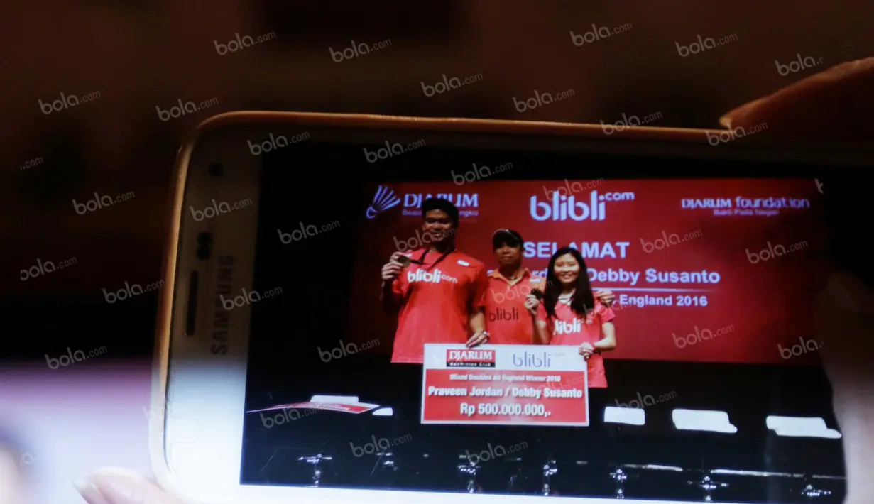 Wartawan mengabadikan momen Praveen Jordan/Debby Susanto, Juara Ganda Campuran All England 2016 berfoto bersama pelatih Richard Mainaky saat menerima bonus dari PB Djarum di Plasa Senayan, Jakarta, Selasa (22/3/2016). (Bola.com/Nicklas Hanoatubun)