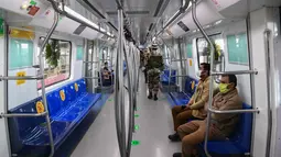 Prajurit berpatroli di kereta metro tanpa pengemudi pertama India selama pratinjau media untuk peresmiannya di New Delhi, Senin (28/12/2020). Kereta tanpa pengemudi itu akan beroperasi di jalur magenta sepanjang 38 kilometer di ibu kota India yang menghubungkan 25 stasiun metro. (Sajjad HUSSAIN/AFP)