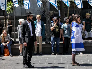 Orang-orang berhenti dan berdiri dalam keheningan selama dua menit pada Hari Peringatan tentara yang gugur (Yom HaZikaron) di Yerusalem pada 25 April 2023. (AFP/RONALDO SCHEMIDT)