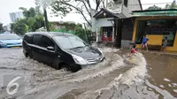 Sejumlah mobil berusaha menerobos banjir di kawasan Kemang Utara, Jakarta Selatan, Rabu (20/7). Akibat intensitas hujan deras yang mengguyur Jakarta, sejumlah ruas jalan tergenang air. (Liputan6.com/Yoppy Renato)