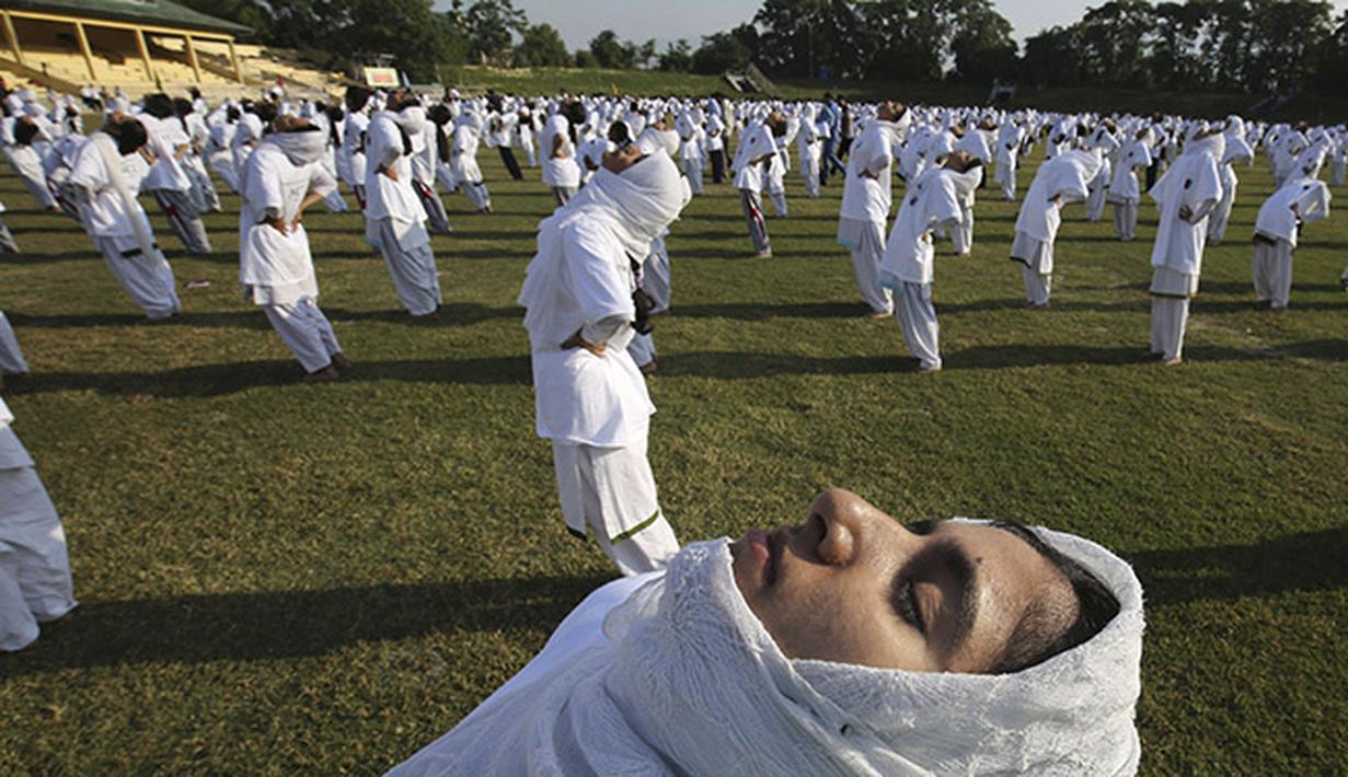 Para siswi pada sebuah sekolah di kota Srinagar, Kashmir melakukan gerakan yoga secara kolektif. (EPA/Farooq Khan)