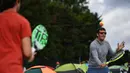 Dua pria bermain bola tenis ketika mereka mengantre untuk membeli tiket pada hari pertama turnamen tenis Kejuaraan Wimbledon 2019 di The All England Tennis Club di Wimbledon, London barat daya (1/7/2019). Turnamen ini dimulai 1 Juli-14 Juli 2019. (AFP Photo/Ben Stansall)