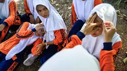 Sejumlah siswa Sekolah Menengah Atas (SMA) mengikuti simulasi gempa bumi dan tsunami untuk memperingati Hari Kesadaran Tsunami Sedunia di Lhoknga, Provinsi Aceh, pada Rabu 5 November 2025. Beberapa skenario mitigasi bencana disimulasikan termasuk penanganan korban luka oleh tim penyelamat atau relawan terlatih. (CHAIDEER MAHYUDDIN/AFP)