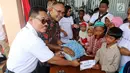 Sekertaris Perusahaan PT ASABRI (Persero) Djoko Rachmadhy memberikan bantuan kepada anak yatim saat perayaan Natal bersama dan bantuan CSR Sinergi BUMN di Kota Waingapu, Sumba Timur, Sabtu (15/12). (Liputan6.com/JohanTallo)