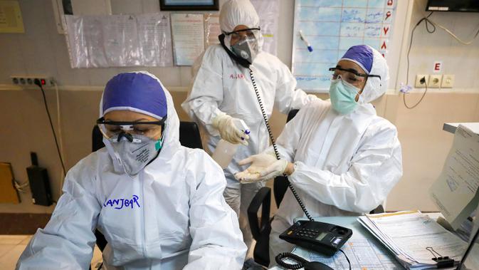 Seorang petugas medis membersihkan tangan rekannya di sebuah rumah sakit yang menangani pasien virus corona atau COVID-19 di Teheran, Iran, Minggu (1/3/2020). Sejauh ini, Iran mencatat ada 1.501 kasus virus corona dengan 66 korban meninggal. (Koosha Mahshid Falahi/Mizan News Agency via AP)