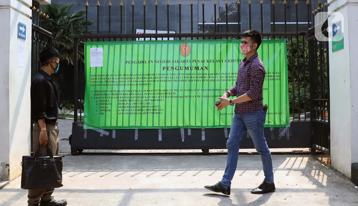 Warga melintas di depan pagar gedung Pengadilan Negeri Jakarta Pusat, Rabu (7/10/2020). Pengadilan Negeri Jakarta Pusat menghentikan aktivitas selama tiga hari terhitung Rabu 7 Oktober hingga 9 Oktober 2020 karena adanya hasil tes pegawai yang reaktif COVID-19. (Liputan6.com/Helmi Fithriansyah)