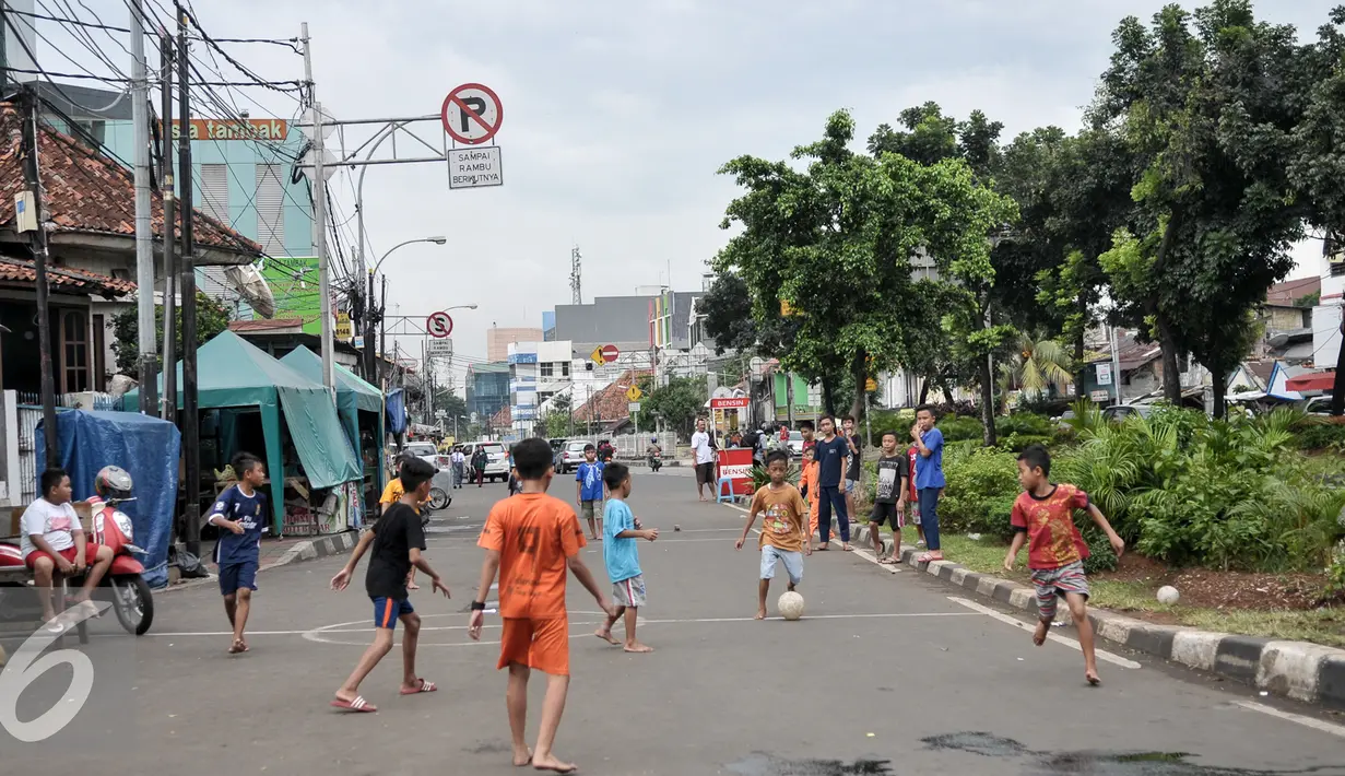 ejumlah anak bermain sepak bola di Jalan Tambak, Manggarai, Jakarta, Jumat (22/7). Minimnya lahan bermain, sejumlah anak manfaatkan jalanan untuk bermain. (Liputan6.com/Yoppy Renato)