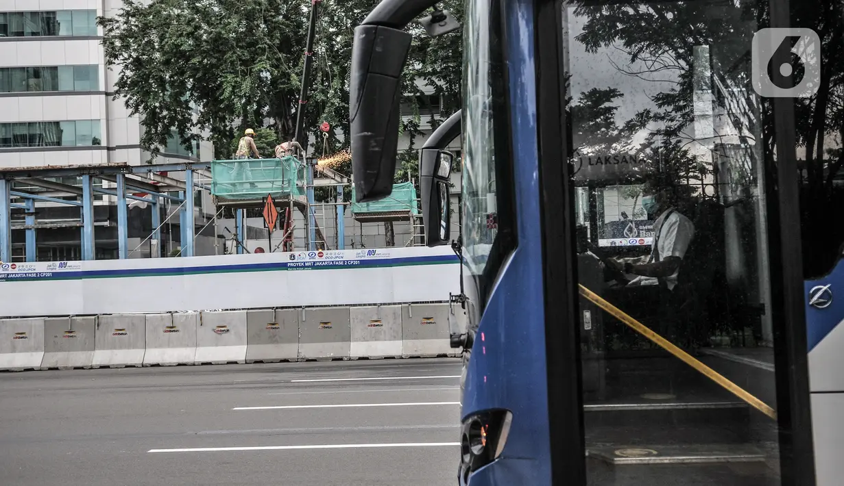 Bus Transjakarta melintas dekat pembongkaran Halte Transjakarta Bank Indonesia di Jalan MH Thamrin, Jakarta, Senin (18/1/2021). Halte tersebut dibongkar untuk kelanjutan proyek MRT Fase 2 CP201 rute Bundaran HI-Harmoni yang ditargetkan rampung pada Maret 2025. (merdeka.com/Iqbal S. Nugroho)