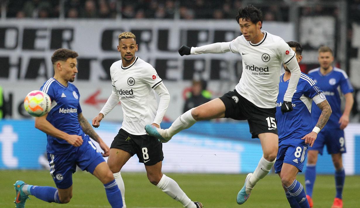 Gelandang Eintracht Frankfurt, Daichi Kamada (kanan) melepaskan tendangan saat menghadapi Schalke dalam laga Bundesliga 2022/2023 di Frankfurt (21/1/2023). Pemain yang sejak awal musim 2017/2018 membela Eintracht Frankfurt ini menjadi pesepak bola Jepang dengan nilai pasar tertinggi. Saat ini Daichi Kamada memiliki nilai pasar senilai 30 juta euro atau setara Rp488 miliar. (AFP/Daniel Roland)