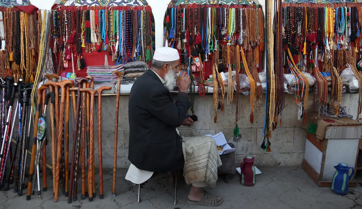 Seorang pedagang minum teh sambil menunggu pelanggan di sebuah pasar tradisional di Kabul, Afghanistan, Rabu (9/10/2019). Pendapatan per kapita Afghanistan tercatat sebesar USD 1.150. (AP Photo/Tamana Sarwary)