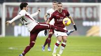 Gelandang AC Milan, Ismael Bennacer berusaha merebut bola dari pemain Torino, Simone Verdi pada pertandingan perempat final Coppa Italia di stadion San Siro, Milan (28/1/2020). AC Milan menang 4-2 atas Torino dan melaju ke babak semifinal melawan Juventus.  (AP Photo/Antonio Calanni)