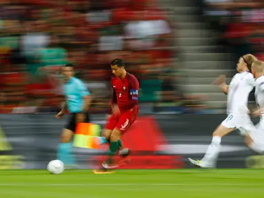 Penyerang Portugal, Cristiano Ronaldo berusaha membawa bola dari kejaran dua pemain Islandia pada laga Grup F Piala Eropa di Stade Geoffroy-Guichard, Prancis, Selasa (14/6). Islandia berhasil tahan imbang Portugal 1-1. (REUTERS/Kai Pfaffenbach)