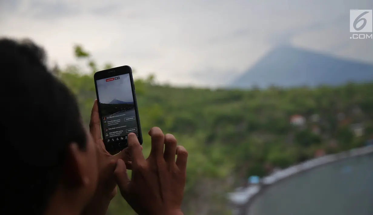 Wisatawan mengambil foto Gunung Agung dari kawasan Pantai Amed, Karangasem, Bali, Rabu (6/12). Kawasan Amed ini juga terkenal dengan lokasi wisata air. (Liputan6.com/Immanuel Antonius)
