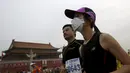 Seorang pelari menggunakan masker saat mengikuti Beijing International Marathon di Beijing, China, Minggu (20/9/2015). Sekitar 30.000 pelari ikut ambil bagian dalam acara yang berlangsung tiap tahun. (REUTERS/Kim Kyung-Hoon)