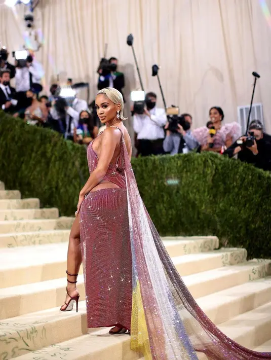 Saweetie tampil mengenakan gaun rancangan Christian Cowan. Gaun ini terinspirasi dari Saweetie sendiri dengan menunjukkan warna bendera Filipina dan Amerika. Ada 10 juta kristal yang ditempatkan secara manual di rantai berlian untuk menghiasi seluruh tubuhnya. Foto: Instagram @christiancowan.