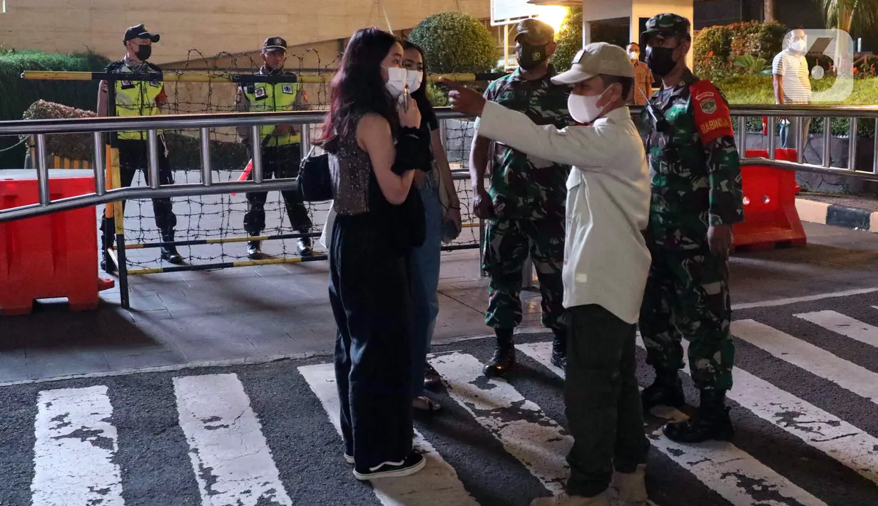 Petugas gabungan melakukan pembubaran terhadap warga yang berkerumun di kawasan Bundaran HI, Jakarta, Jumat (31/12/2021). Petugas gabungan melarang perayan malam pergantian tahun di wilayah Jakarta untuk mencegah penyebaran COVID-19. (Liputan6.com/Angga Yuniar)