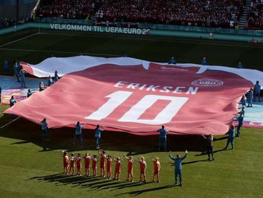 Ada momen menarik pada laga Denmark kontra Belgia pada pertandingan kedua Grup B Piala Eropa 2020. Jersey Christian Eriksen berukuran raksasa dibentangkan di tengah lapangan pada laga tersebut. (Hannah McKay/Pool via AP)