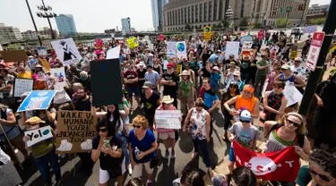 Sejumlah orang melakukan demonstrasi bertepatan 100 hari kerja Trump sebagai presiden di Market Street di Philadelphia, AS, Sabtu (29/4). Demonstran memprotes kebijakan Presiden Donald Trump terkait perubahan iklim. (AP Photo / Matt Rourke)