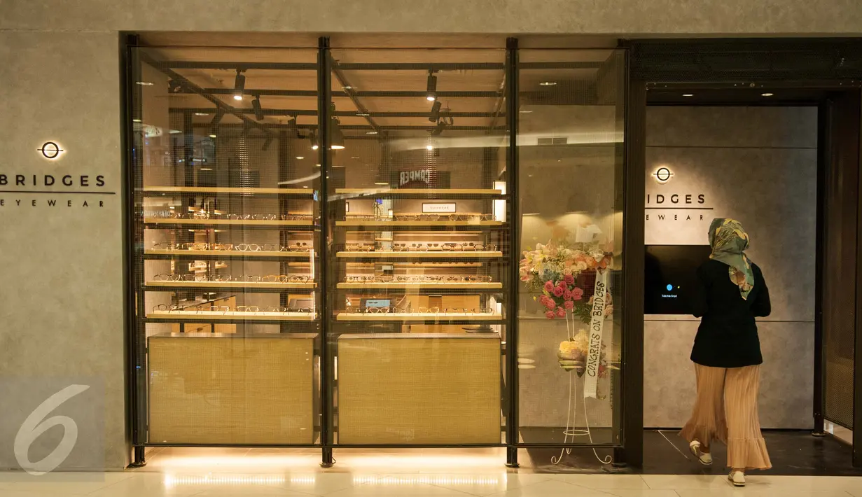 Pengunjug memasuki toko kacamata Bridges di Senayan City, Jakarta, Rabu (17/5). Bridges Eyewear, brand lokal yang menawarkan ragam koleksi kacamata stylish kembali membuka gerai terbarunya di Senayan City, Jakarta. (Liputan6.com/Gempur M Surya)